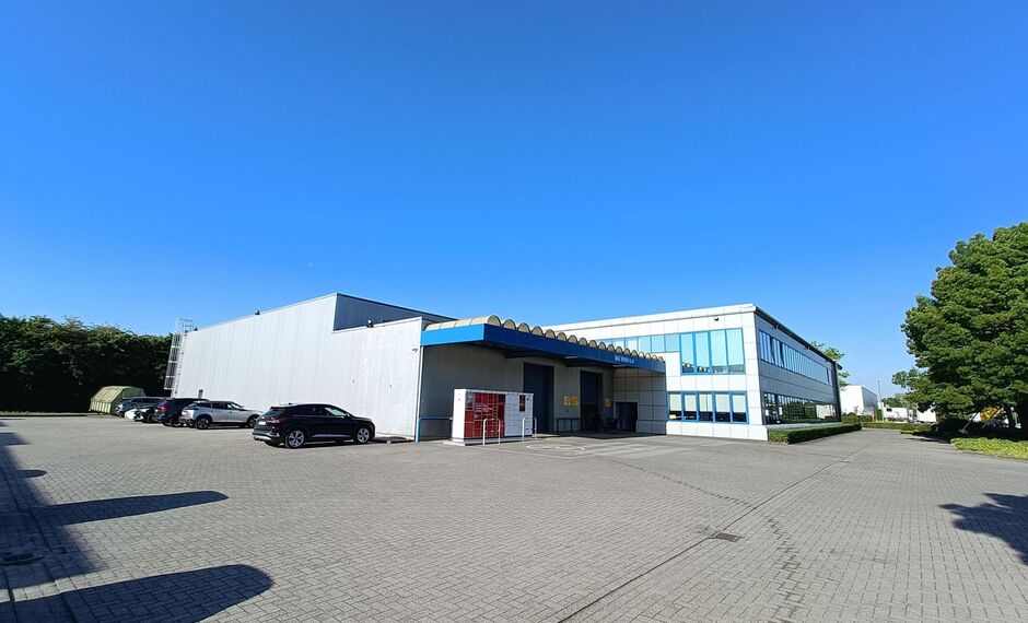 Dit bedrijfsgebouw is strategisch gelegen te Wommelgem, in de goed ontsloten KMO-zone 'Kapelleveld', vlakbij de E313-E34 richting Antwerpen, Nederland en Luik.
Het pand, gelegen op een privatief perceel van ca. 7.576 m², bestaat uit de combinatie van o